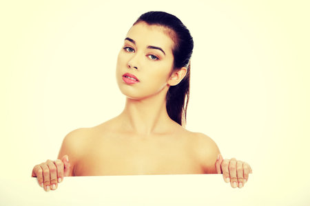 Nude woman holding blank banner.の写真素材