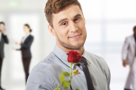 Young handsome man holding red rose.の写真素材