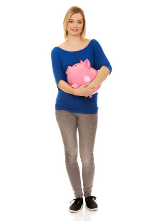 Happy young woman holding piggybank.の写真素材