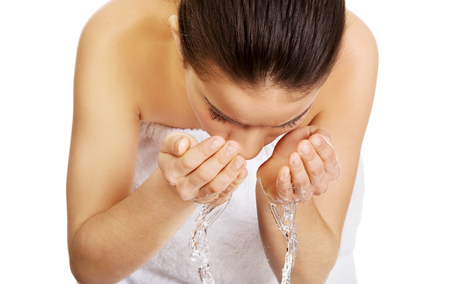 Woman washing her clean face with water.の写真素材