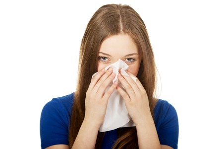 Young ill woman using a tissue.の写真素材