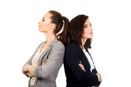 Two offended businesswomen leaning on each other.の写真素材
