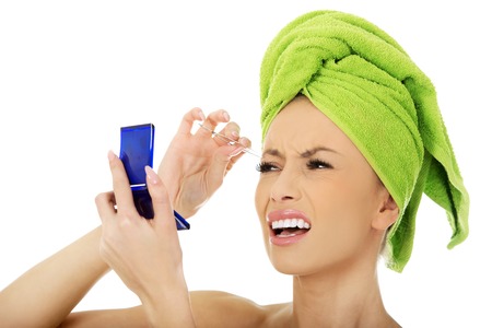 Beautiful caucasian woman plucking her eyebrow.の写真素材