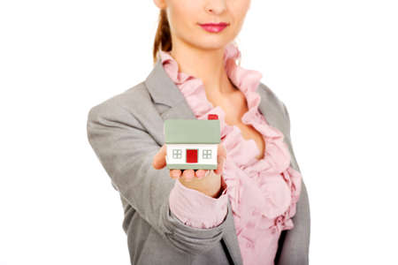 Beautiful businesswoman holding a house model.の写真素材