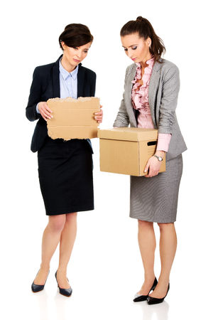 Two fired businesswoman with a box and piece of carton.の写真素材