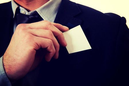 Young businessman taking his personal card from pocket.