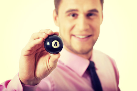 Young handsome businessman holding billiard ball.