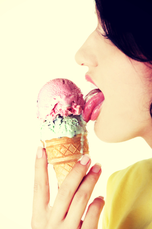 Side view young woman eating an ice cream.の写真素材
