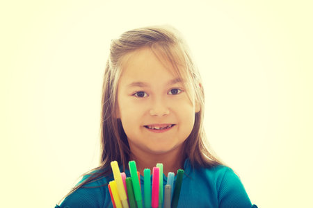 Pretty little girl holding crayons in handsの写真素材