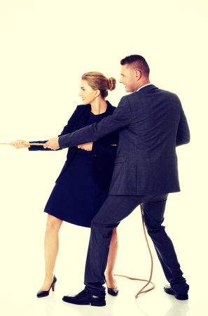 Business partners supporting each other by draging a ropeの写真素材