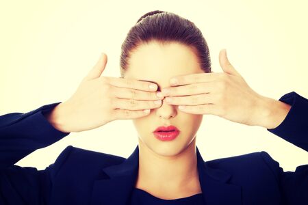 Beautiful woman covering her eyes with her handsの写真素材