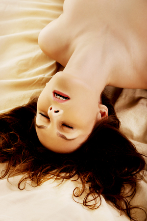 Young naked woman in bed getting orgasm.の写真素材