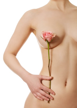 Beautiful woman covers breast with flower.の写真素材