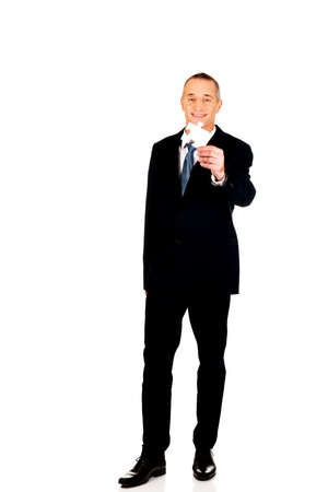 Smart mature businessman holding a puzzleの写真素材