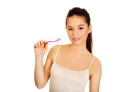 Young beautiful woman holding toothbrush and smiling.の写真素材