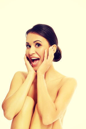 Shocked slim woman sitting with bended knees.の写真素材