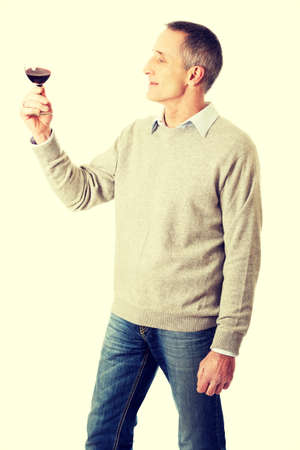 Handsome mature man tasting red wine.の写真素材