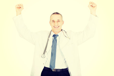 Cheerful mature male doctor with raised arms.の写真素材