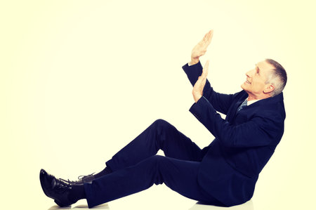 Frightened businessman protecting himself from empty space.の写真素材