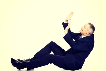 Frightened businessman protecting himself from empty space.の写真素材