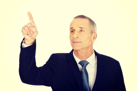 Mature businessman pressing abstract button.の写真素材