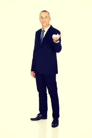 Mature businessman holding small airplane.の写真素材