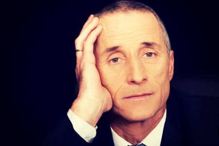 Portrait of serious businessman sitting at desk.の写真素材