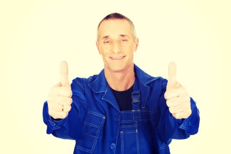 Mature repairman showing thumbs up.の写真素材