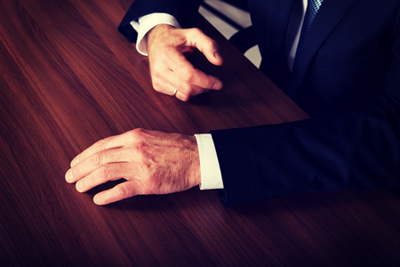 Mature businessman's hands put on the desk.の写真素材