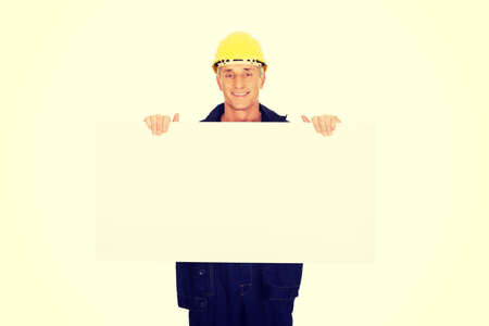 Happy mature worker presenting empty banner.の写真素材