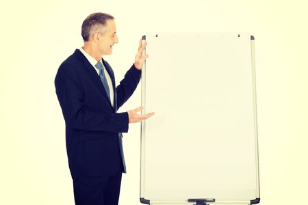 Mature businessman presenting something on flip chart.の写真素材
