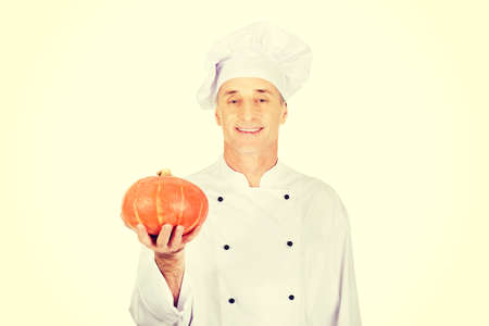 Male chef in uniform holding a pumpkinの写真素材