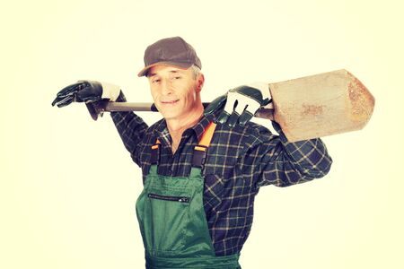 Smiling experienced gardener with a spade on shouldersの写真素材