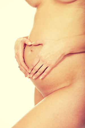 Woman touching her growing pregnant bellyの写真素材
