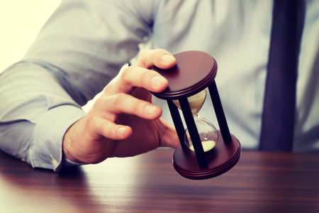 Businessman holding hourglass in the office.