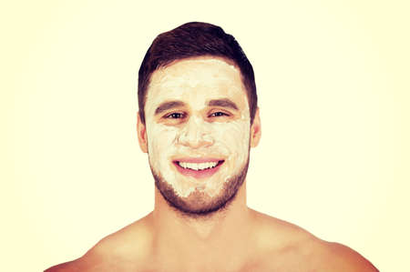 Handsome man with cream moisturizer on his face.の写真素材