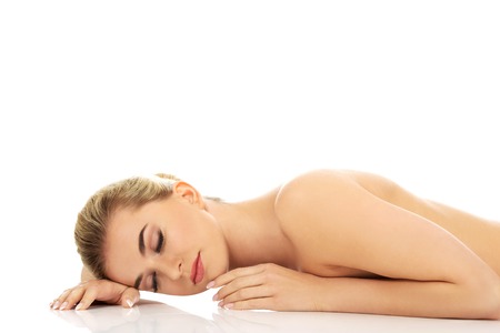 Beautiful naked slim woman lying on the floor.の写真素材