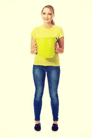Young student woman holding green bucket.の写真素材