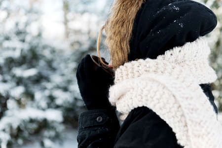 Teenage woman holding a cup of hot drink outdoorsの写真素材