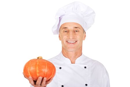 Male chef in uniform holding a pumpkinの写真素材