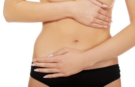 Young woman belly with hand on it, isolated on whiteの写真素材