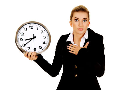 Young businesswoman terrified looks at the clock. Time concept