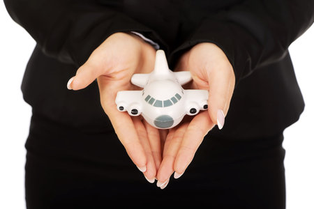 Businesswoman presenting plane model in hand.の写真素材