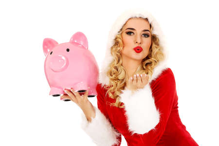 Santa woman holding a piggy bank and sending a kiss.の写真素材