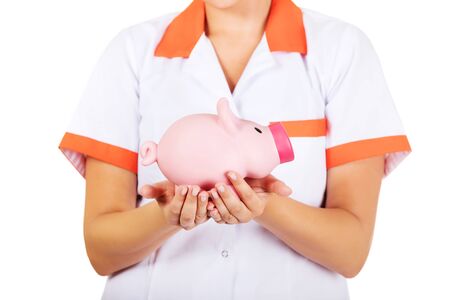 Young female doctor or nurse holding a piggybank.の写真素材