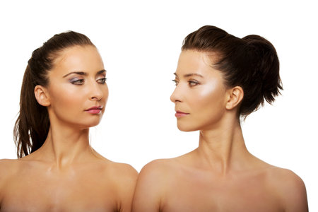 Two attractive topless sisters with make up.の写真素材