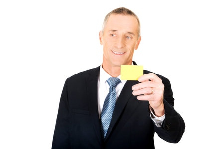 Mature businessman showing a yellow identity name card.の写真素材