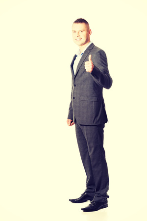 Young smiling businessman gesturing thumbs up.の写真素材