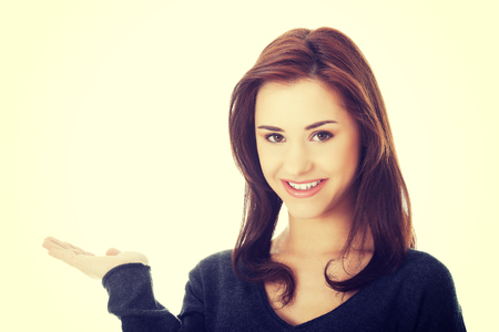 Smiling woman holding something imaginary on palmの写真素材