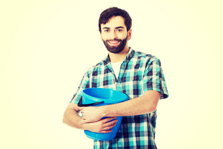 Young handsome man holding plastic blue bucket.の写真素材